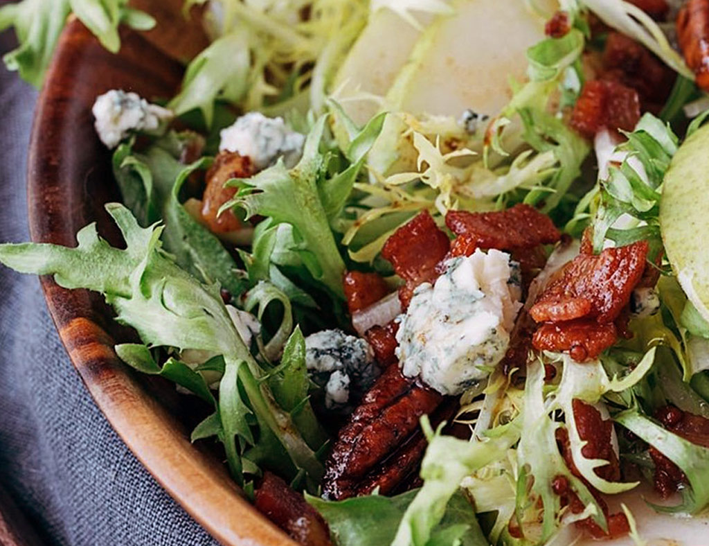 Bowl of Asian Salad with pecans, topped with blue cheese.