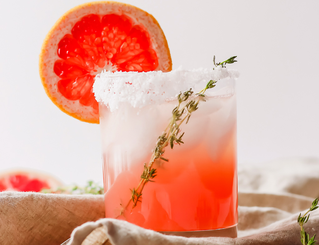 Beautiful glass with The Paloma Cocktail garnished with a slice of grapefruit.