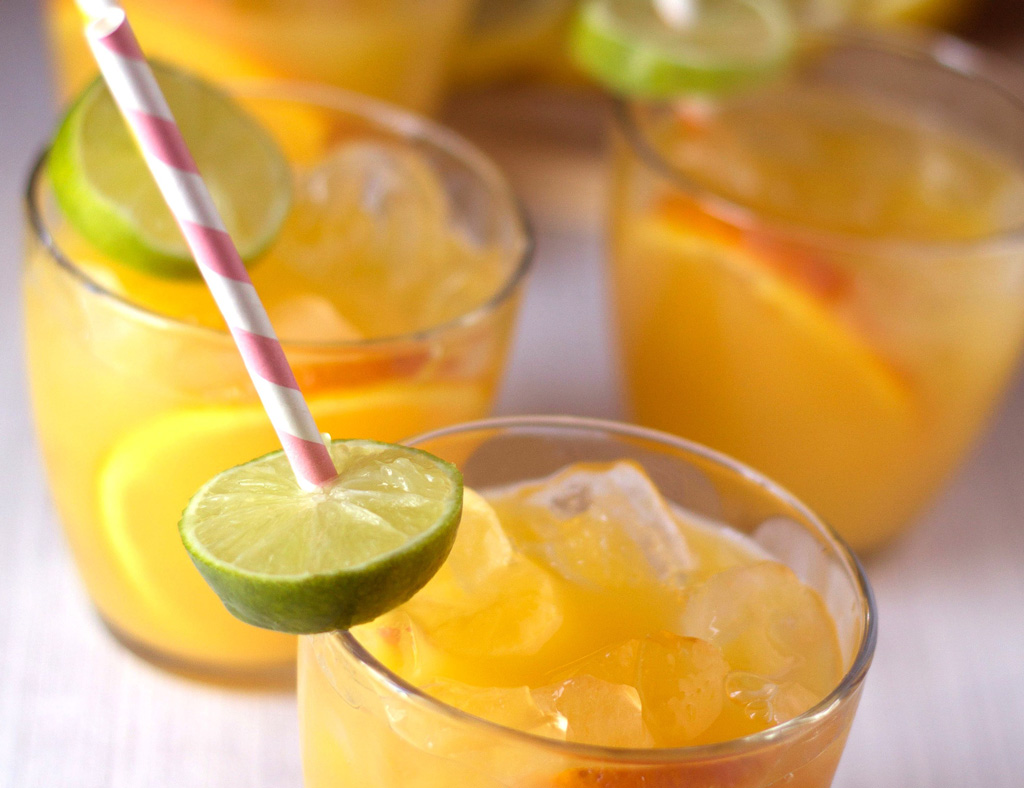 Several glasses with Fruit Punch, ice and citrus slices.