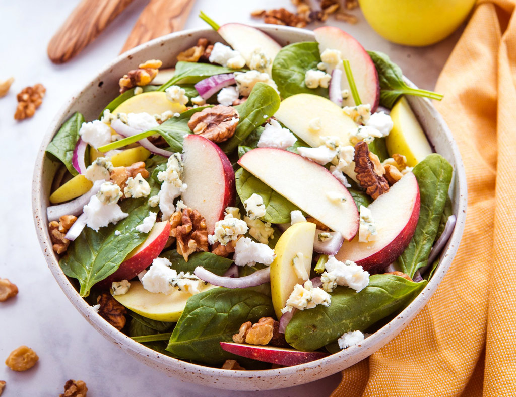 Beautiful bowl with Green Salad With Maple-Cider Vinaigrette in it.